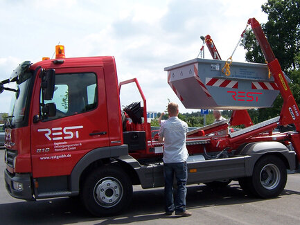 Fahrzeug hebt Absetzcontainer hoch
