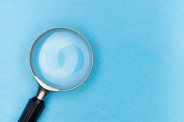 Eine Lupe vor einem blauen Hintergrund.