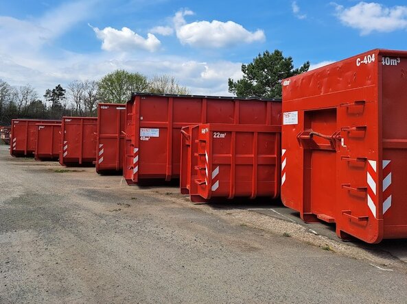 Rote Abrollcontainer auf einer offenen Fläche